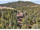 Aerial view of home nestled within a lush forest, creating a private and secluded retreat at 20957 Horse Bit Way, Morrison, CO 80465