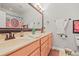 Well-lit bathroom with double sinks and modern fixtures, complemented by a decorative shower curtain at 20957 Horse Bit Way, Morrison, CO 80465