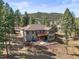Two-story home with a spacious deck and patio featuring stunning mountain views at 20957 Horse Bit Way, Morrison, CO 80465