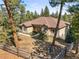 Aerial view showcasing a well-maintained home with a manicured lawn amidst a serene forest backdrop at 20957 Horse Bit Way, Morrison, CO 80465