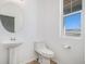 Powder room with pedestal sink, toilet, and a window with a view at 5367 Spring Ridge Trl, Castle Rock, CO 80104