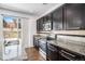 This kitchen features stainless steel appliances, dark cabinets, and granite countertops with a view to the outside at 5367 Spring Ridge Trl, Castle Rock, CO 80104