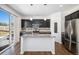 Modern kitchen features dark cabinets, stainless steel appliances, and a granite island with a sink at 5367 Spring Ridge Trl, Castle Rock, CO 80104