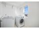 Well-lit laundry room with modern appliances, including a washer and dryer, plus wire rack shelving at 5367 Spring Ridge Trl, Castle Rock, CO 80104