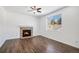 Cozy living room showcasing a stone fireplace, hardwood floors, a ceiling fan, and natural light at 5367 Spring Ridge Trl, Castle Rock, CO 80104