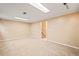 View of a large basement with neutral carpet, two lighting fixtures, and a stairwell at 10311 E Evans Ave # 132, Aurora, CO 80247