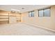 Finished basement features built-in shelving, carpet, lighting, and two small basement windows at 10311 E Evans Ave # 132, Aurora, CO 80247