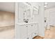 Bright bathroom with double vanity, white cabinets, and two mirrors with modern fixtures at 10311 E Evans Ave # 132, Aurora, CO 80247