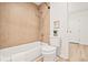 Tiled bathtub and shower combination, toilet, and a door in the neutrally-colored bathroom at 10311 E Evans Ave # 132, Aurora, CO 80247