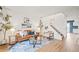 Bright living room features a brown leather couch, eye-catching decor, and a staircase leading upstairs at 10311 E Evans Ave # 132, Aurora, CO 80247