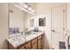 Bright bathroom featuring a large mirror, granite vanity, and plenty of light at 2855 Blue Sky Cir # 3-102, Erie, CO 80516