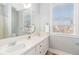 Well-lit bathroom with double sinks, a large mirror, and a window offering natural light and a view at 11687 Newton St, Westminster, CO 80031