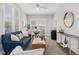 Bright and airy living room with a blue sofa, accent chairs, and ample natural light from multiple windows at 11687 Newton St, Westminster, CO 80031