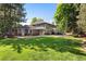 Expansive backyard with lush lawn, mature trees, and a large patio area at 5643 S Fulton Way, Greenwood Village, CO 80111