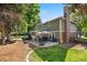 Scenic backyard view with patio, fireplace, furniture set, and mature trees at 5643 S Fulton Way, Greenwood Village, CO 80111