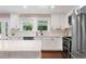 Modern kitchen with stainless steel appliances, white cabinets, and marble backsplash at 5643 S Fulton Way, Greenwood Village, CO 80111