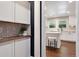 Hallway view into kitchen with island seating, modern appliances and white cabinetry at 5643 S Fulton Way, Greenwood Village, CO 80111