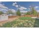 Fenced backyard with a storage shed, garden, and lush green grass under a bright sky at 17731 E Bails Pl, Aurora, CO 80017