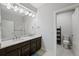 Elegant bathroom with a double sink vanity, bright lighting, and a separate toilet area at 5608 Raintree Dr, Parker, CO 80134