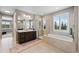 Luxurious bathroom with a large soaking tub, glass-enclosed shower, and double vanity at 5608 Raintree Dr, Parker, CO 80134