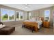 Bedroom featuring a wooden bed, bench, windows, ceiling fan, and relaxing chair at 5608 Raintree Dr, Parker, CO 80134