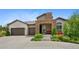 Charming stucco home with a stone archway and three-car garage, set in a landscaped front yard at 5608 Raintree Dr, Parker, CO 80134