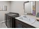 Well-equipped laundry room with modern washer, dryer, and convenient folding area at 5608 Raintree Dr, Parker, CO 80134