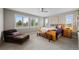 Bright main bedroom with plush chair, bench, ceiling fan, carpet, and plantation shutters at 5608 Raintree Dr, Parker, CO 80134