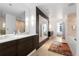 Bathroom with a large mirror over a double sink vanity, tile floor, and a view into another room, creating an open feel at 105 Fillmore St # 209, Denver, CO 80206