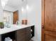 Bathroom featuring modern vanity with unique sink fixtures, decorative accents, and warm wood door adding character at 105 Fillmore St # 209, Denver, CO 80206