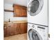 Functional laundry room with stacked washer and dryer, wooden cabinets, and sink, providing ample storage at 105 Fillmore St # 209, Denver, CO 80206