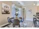 Elegant dining area with a round table, velvet chairs, and a view of the outdoors through a large window at 5677 S Park Pl # C111, Englewood, CO 80111