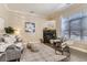 Cozy living room featuring a fireplace, plush seating, stylish decor, and abundant natural light from a large window at 5677 S Park Pl # C111, Englewood, CO 80111