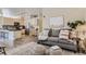 Comfortable living room with a gray sofa, decorative pillows, a patterned rug, and easy access to the kitchen at 5677 S Park Pl # C111, Englewood, CO 80111