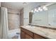 Bathroom features a vanity with granite countertop and a tiled shower with curtain at 6021 Yarrow St # B13, Arvada, CO 80004