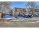 Multi-unit townhouse complex showcases exterior stairs, balconies, and snow-covered landscaping on a sunny day at 6021 Yarrow St # B13, Arvada, CO 80004