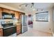Modern kitchen featuring stainless steel appliances, wooden cabinets, and an opening to the adjacent room at 6021 Yarrow St # B13, Arvada, CO 80004