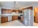 A kitchen with brown cabinets, stainless steel appliances, and granite countertops at 6021 Yarrow St # B13, Arvada, CO 80004