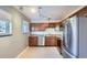 Updated kitchen with wood cabinets, tile floor, and stainless steel appliances at 6021 Yarrow St # B13, Arvada, CO 80004