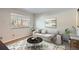 Well-lit living room features a cozy sofa, round table, and view of the outside through a bright window at 6021 Yarrow St # B13, Arvada, CO 80004