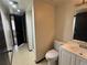 Bathroom featuring a single vanity, toilet, shower, and tile flooring at 1825 Kendall St # 205, Lakewood, CO 80214