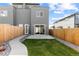 Modern home's backyard features a cozy patio, a small lawn, and a wood fence for privacy at 2466 S Cherokee St, Denver, CO 80223
