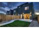 Modern home exterior featuring a well-kept lawn, privacy fence, and sleek outdoor lighting at 2466 S Cherokee St, Denver, CO 80223