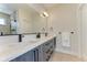 Modern bathroom featuring double vanity with gray wood cabinets and a glass-enclosed shower at 2466 S Cherokee St, Denver, CO 80223