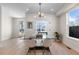 Bright dining room with hardwood floors and a modern chandelier over a glass table at 2466 S Cherokee St, Denver, CO 80223