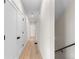 Long, naturally lit hallway with hardwood floors and white doors at 2466 S Cherokee St, Denver, CO 80223
