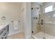 A glass shower with neutral tile, window, and updated hardware, adds a modern touch at 2466 S Cherokee St, Denver, CO 80223
