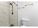 Updated bathroom featuring a tiled shower with a modern showerhead and stylish gold fixtures at 9235 Quintero St, Commerce City, CO 80022