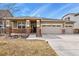 Charming home boasts a three car garage, stone accents and a covered porch with well-manicured landscaping at 9235 Quintero St, Commerce City, CO 80022