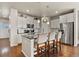 Bright kitchen features an island with seating, granite countertops, stainless steel appliances, and white cabinets at 9235 Quintero St, Commerce City, CO 80022